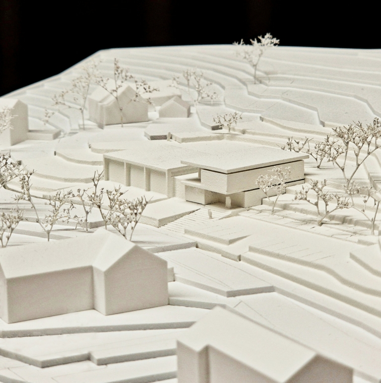 Wettbewerb Neubau Rüsthaus FF Techelsberg, Modellfoto aus dem Juryprotokoll mit umliegender Umgebung